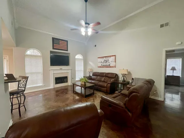 a living room with furniture a fireplace and a flat screen tv