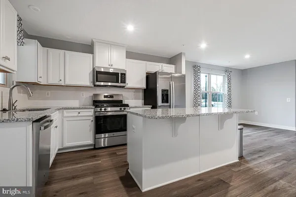 a kitchen with stainless steel appliances a stove sink microwave and cabinets