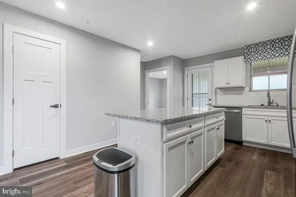 a kitchen with granite countertop a white cabinets and white appliances