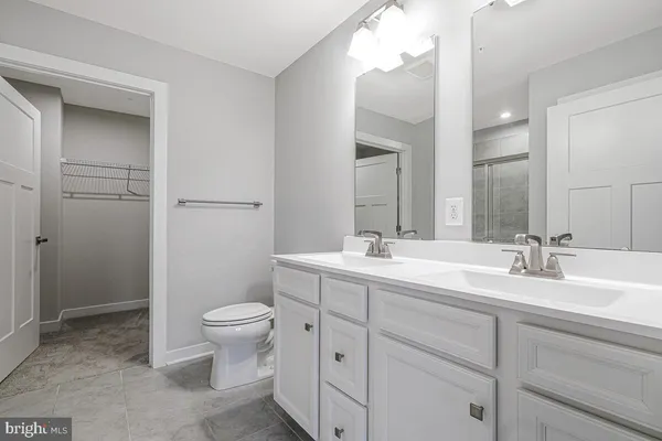 a bathroom with a double vanity sink toilet and a mirror