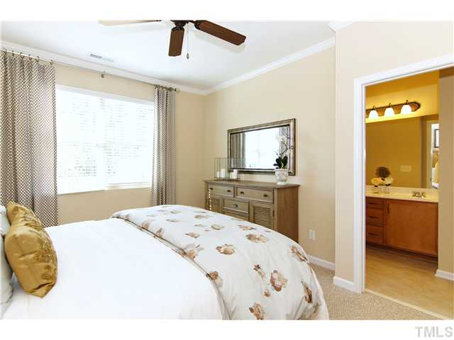 759 Wickham Ridge Road, Unit 105 Apex, NC 27539 - Photo 16 of 25 a bedroom with a bed and a view of kitchen