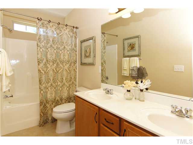 759 Wickham Ridge Road, Unit 105 Apex, NC 27539 - Photo 17 of 25 a bathroom with a sink a toilet and shower