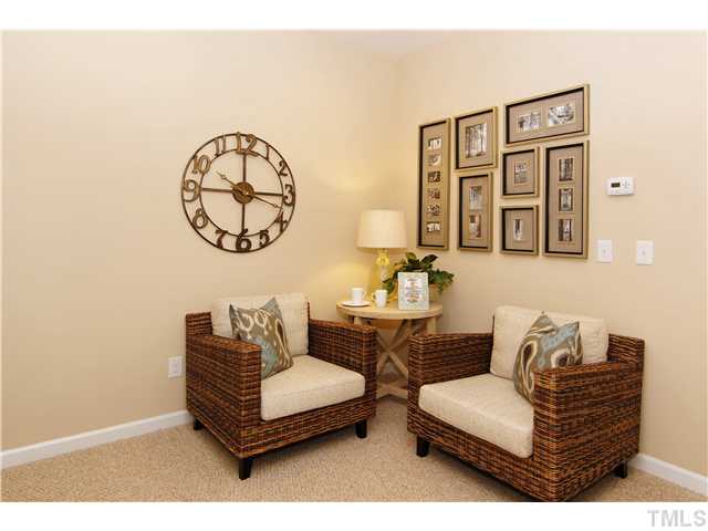 759 Wickham Ridge Road, Unit 105 Apex, NC 27539 - Photo 21 of 25 a living room with furniture a wall clock and a window