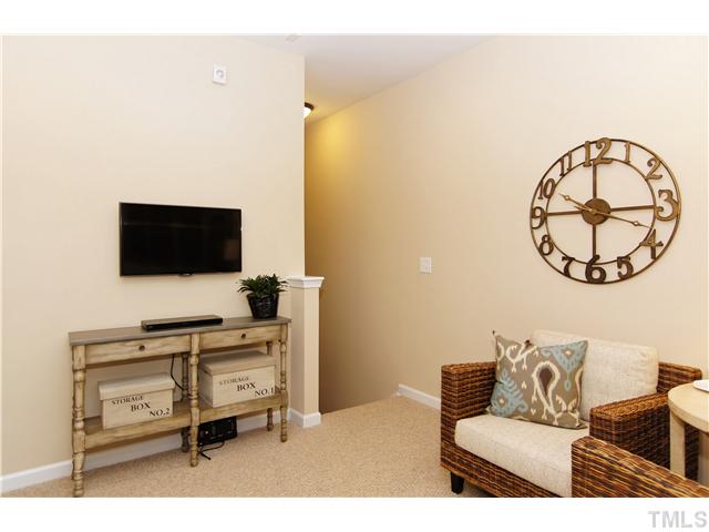 759 Wickham Ridge Road, Unit 105 Apex, NC 27539 - Photo 22 of 25 a living room with furniture and a flat screen tv