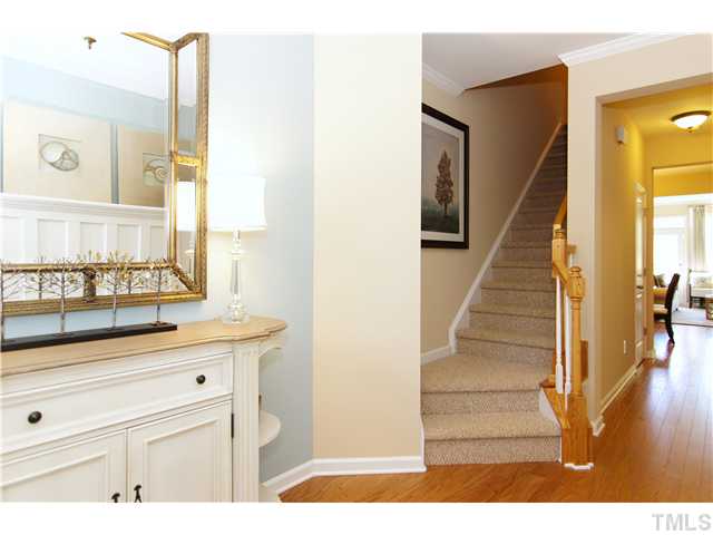 759 Wickham Ridge Road, Unit 105 Apex, NC 27539 - Photo 4 of 25 a view of a hallway with wooden floor and staircase