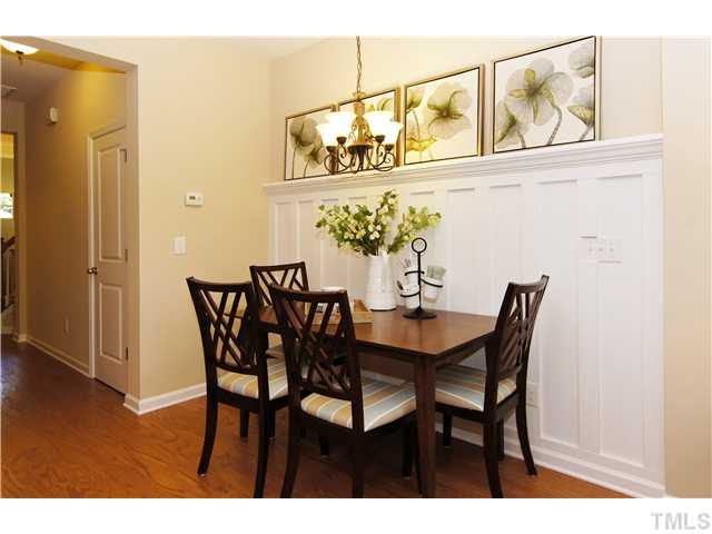 759 Wickham Ridge Road, Unit 105 Apex, NC 27539 - Photo 5 of 25 a view of a dining room with furniture and wooden floor