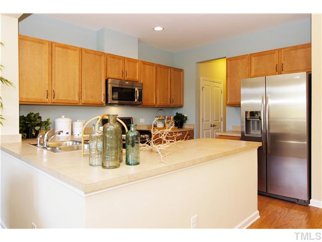 759 Wickham Ridge Road, Unit 105 Apex, NC 27539 - Photo 7 of 25 a kitchen with stainless steel appliances granite countertop a sink a refrigerator and a granite counter tops