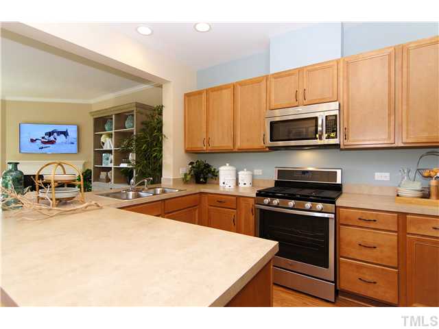 759 Wickham Ridge Road, Unit 105 Apex, NC 27539 - Photo 8 of 25 a kitchen with stainless steel appliances granite countertop a stove top oven a sink dishwasher and cabinets with wooden floor