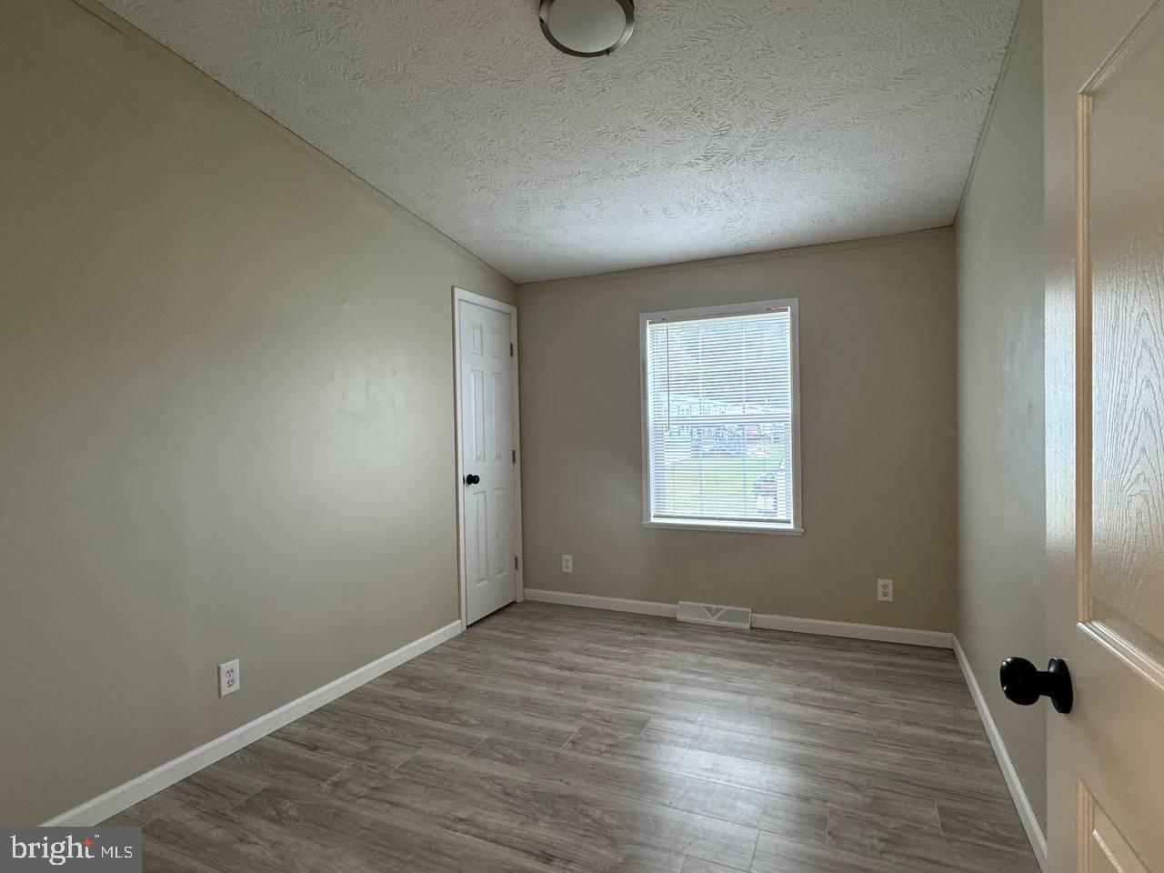 235 Poclain Road Aberdeen, MD 21001 - Photo 12 of 28 an empty room with wooden floor and windows