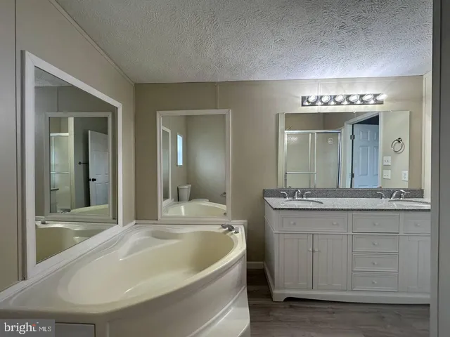 a bathroom with a tub sink and mirror