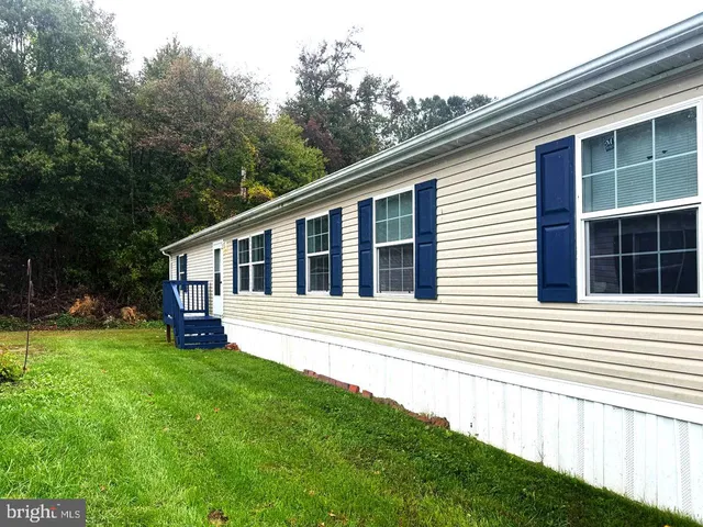 a view of a house with a yard and sitting area