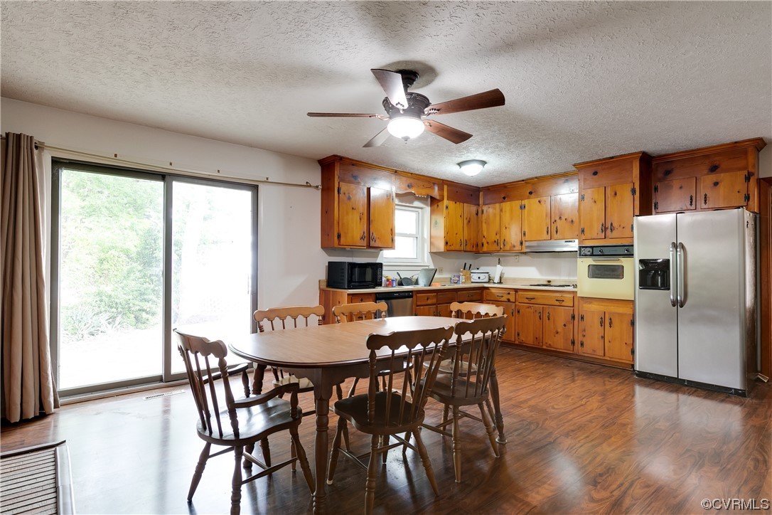 900 Jordan Point Road Hopewell, VA 23860 - Photo 11 of 41 a kitchen with stainless steel appliances granite countertop a dining table chairs refrigerator and cabinets