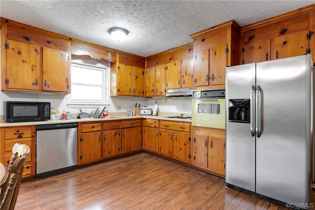 900 Jordan Point Road Hopewell, VA 23860 - Photo 13 of 41 a kitchen with stainless steel appliances granite countertop a refrigerator a sink dishwasher a stove with wooden cabinets and floor