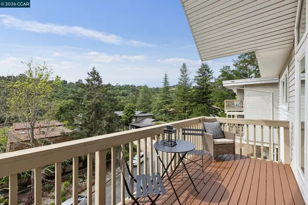 a view of a deck with wooden floor and fence next to a yard