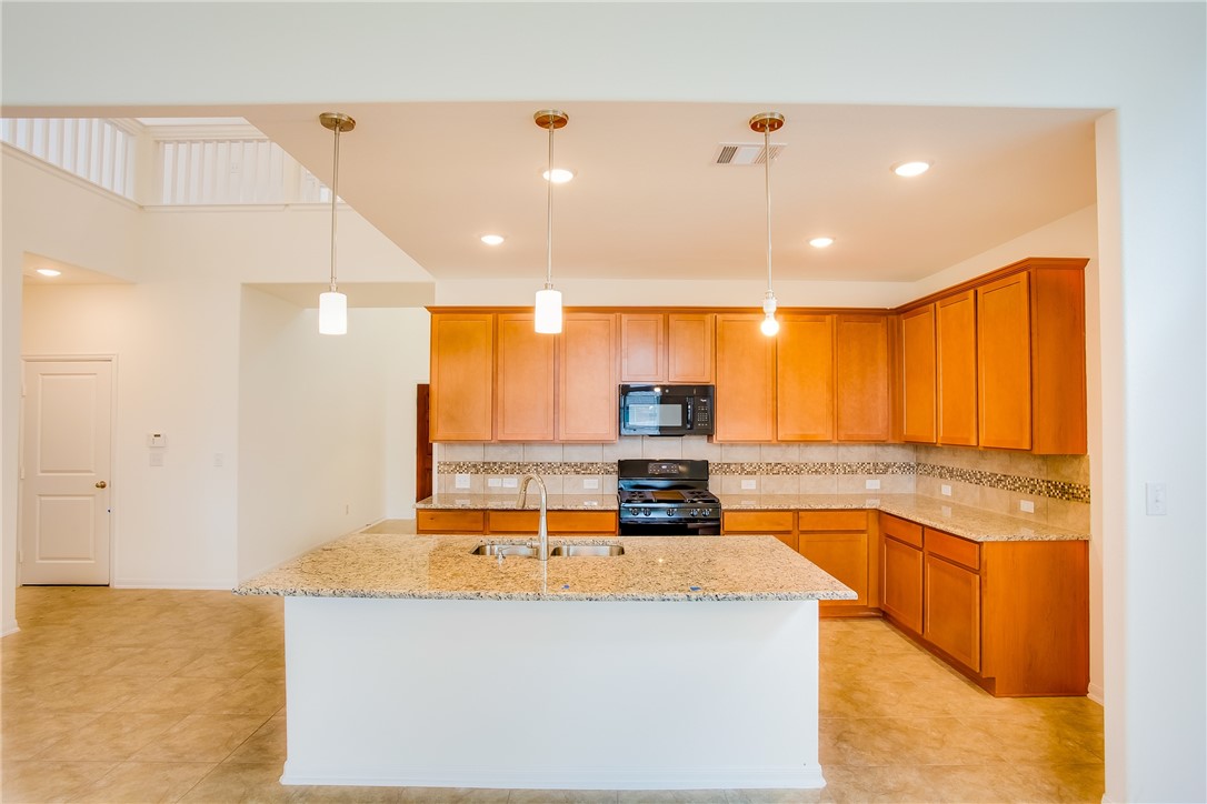 112 Rebel Red Road Liberty Hill, TX 78642 - Photo 12 of 29 a kitchen with stainless steel appliances kitchen island granite countertop a sink and cabinets