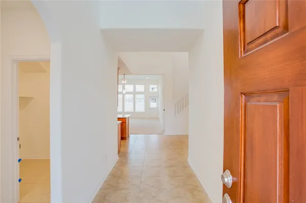 a hallway with wooden floor and a window