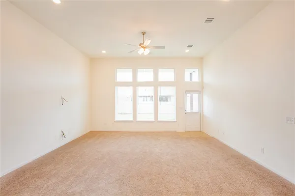 an empty room with a window and a ceiling fan