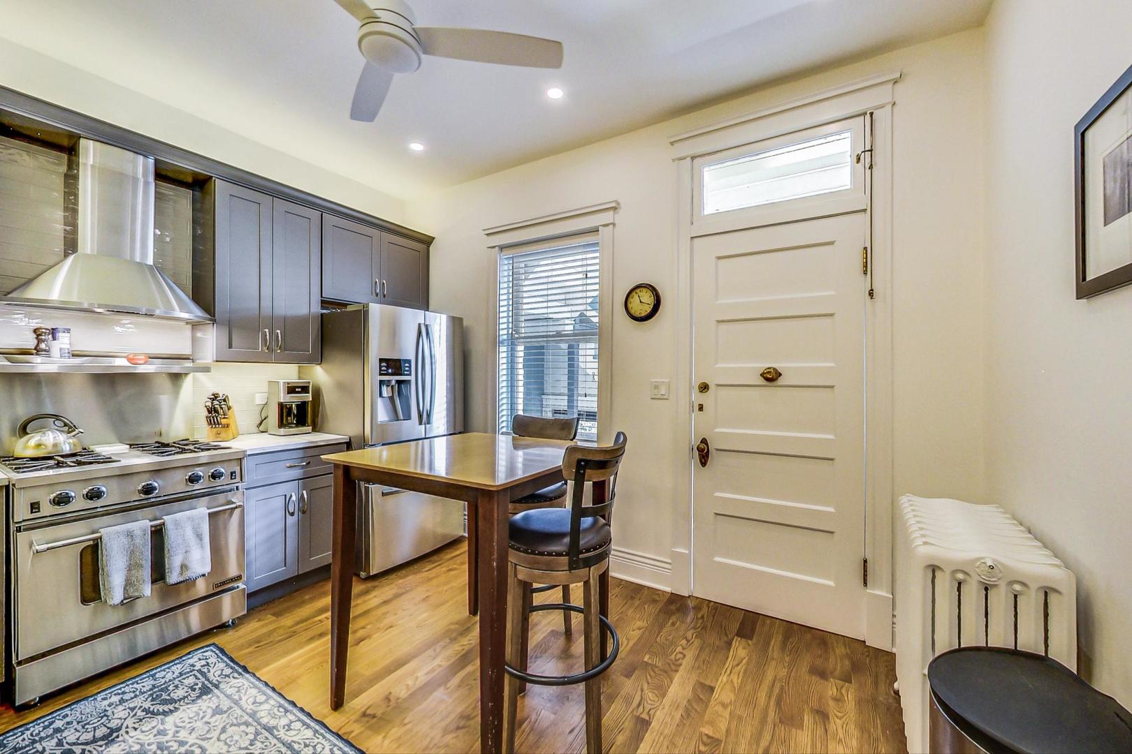1934 West Grace Street Chicago, IL 60613 - Photo 11 of 34 a kitchen with stainless steel appliances granite countertop a stove a refrigerator and a cabinets with wooden floors