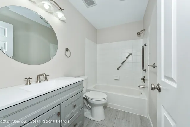 a bathroom with a granite countertop toilet sink and a mirror