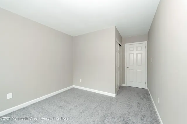 an empty room with white walls and windows