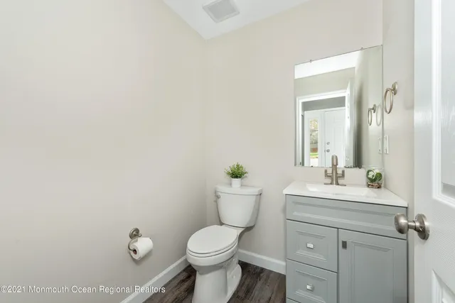 a bathroom with a sink mirror vanity and toilet