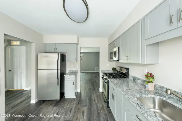 a kitchen with stainless steel appliances granite countertop a refrigerator a sink a stove and oven