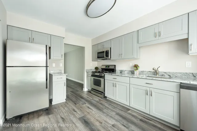 a kitchen with granite countertop a refrigerator stove and sink