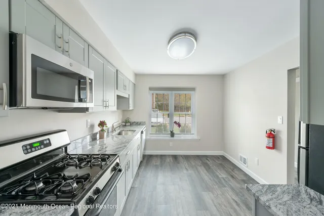 a kitchen with a stove a sink and a microwave