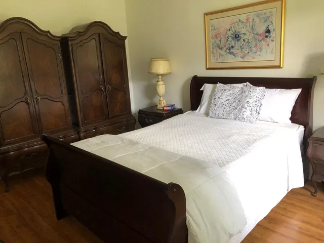 a bedroom with a bed and a painting on the wall