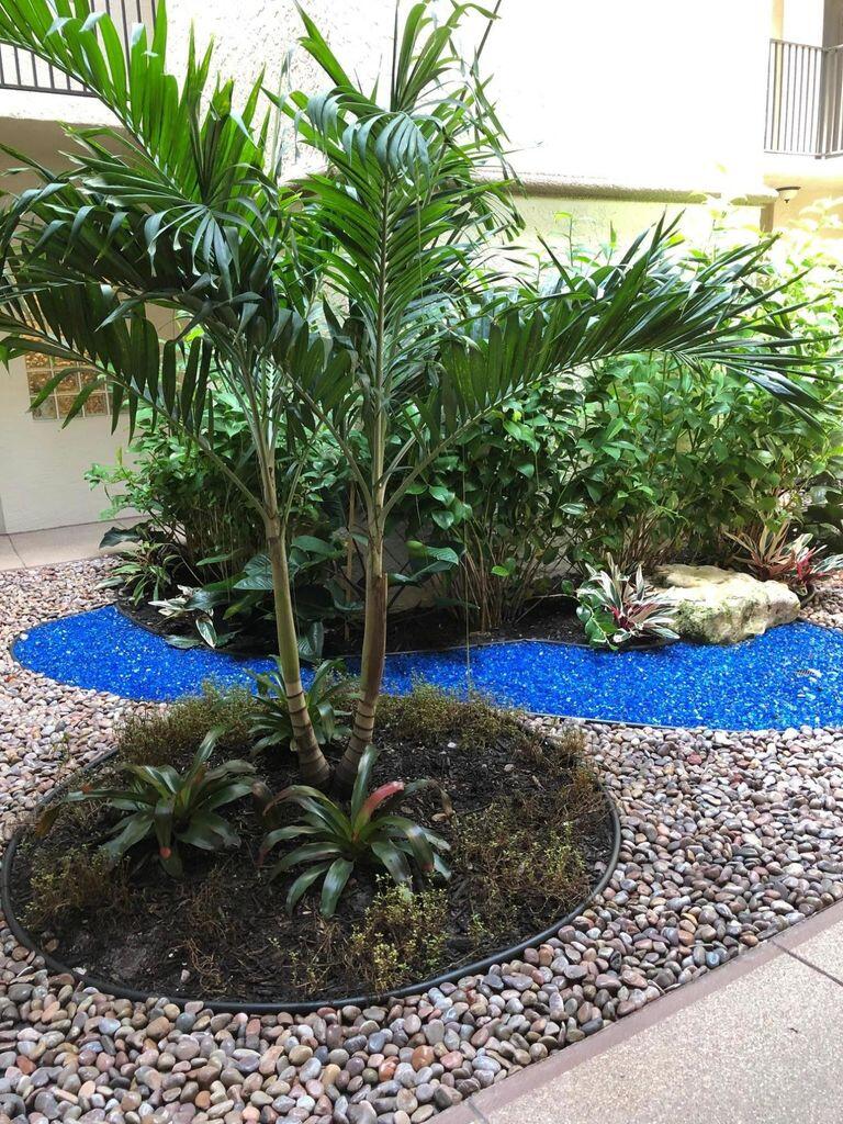 5265 Brisata Circle, Unit E Boynton Beach, FL 33437 - Photo 22 of 30 a view of a garden with a bench