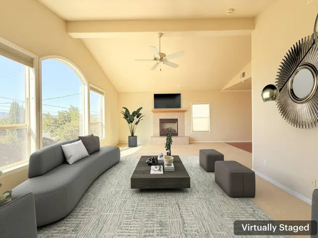 a living room with furniture a fireplace and a large window