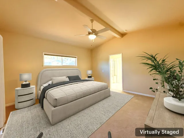 a bedroom with a large bed and a potted plant