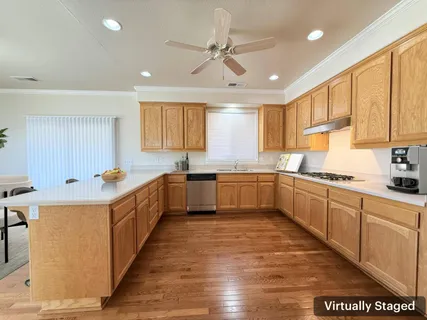 a large kitchen with stainless steel appliances granite countertop a sink counter space cabinets and a large window