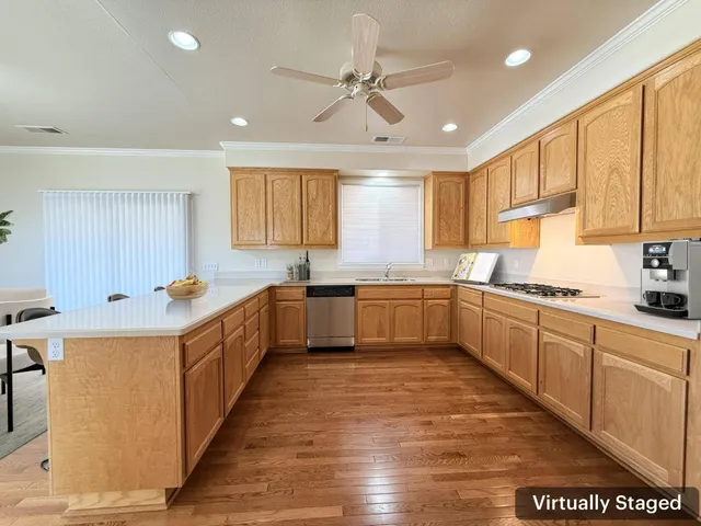 a large kitchen with stainless steel appliances granite countertop a sink counter space cabinets and a large window