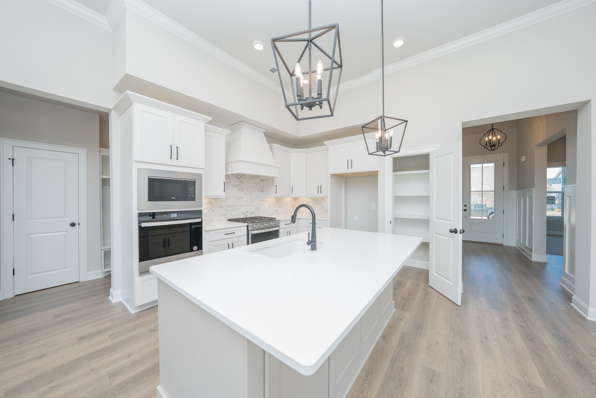 3033 Shandor St Spring Hill Spring Hill, TN 37174 - Photo 13 of 70 a large white kitchen with a stove a sink dishwasher and a refrigerator with wooden floor