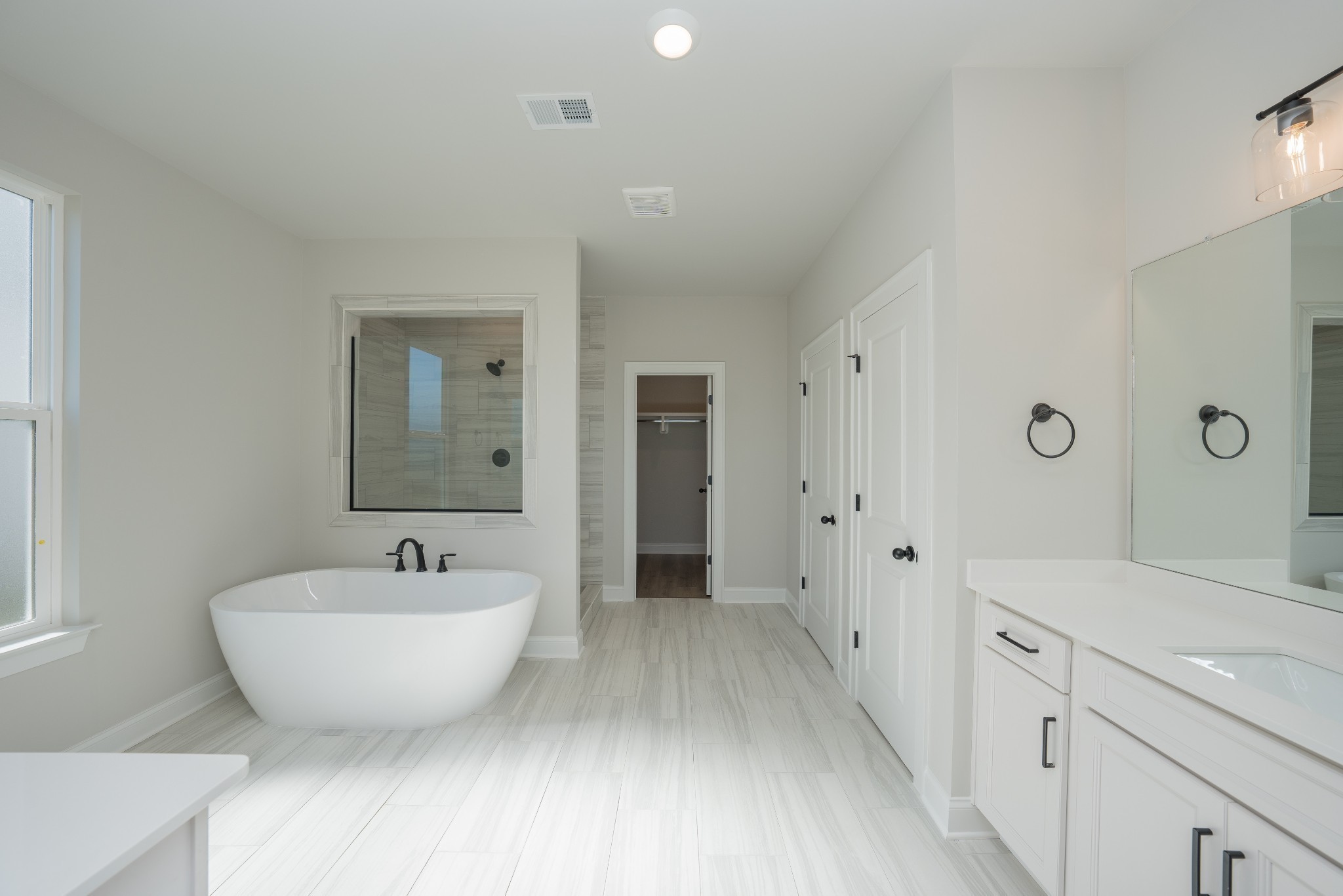 3033 Shandor St Spring Hill Spring Hill, TN 37174 - Photo 29 of 70 a spacious bathroom with a double vanity sink a mirror and a bathtub