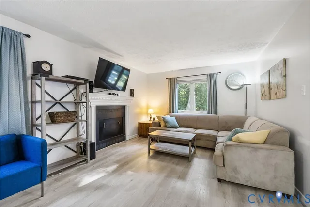 a living room with furniture a flat screen tv and a fireplace