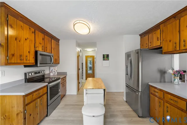 a kitchen with stainless steel appliances granite countertop a stove refrigerator sink and dishwasher