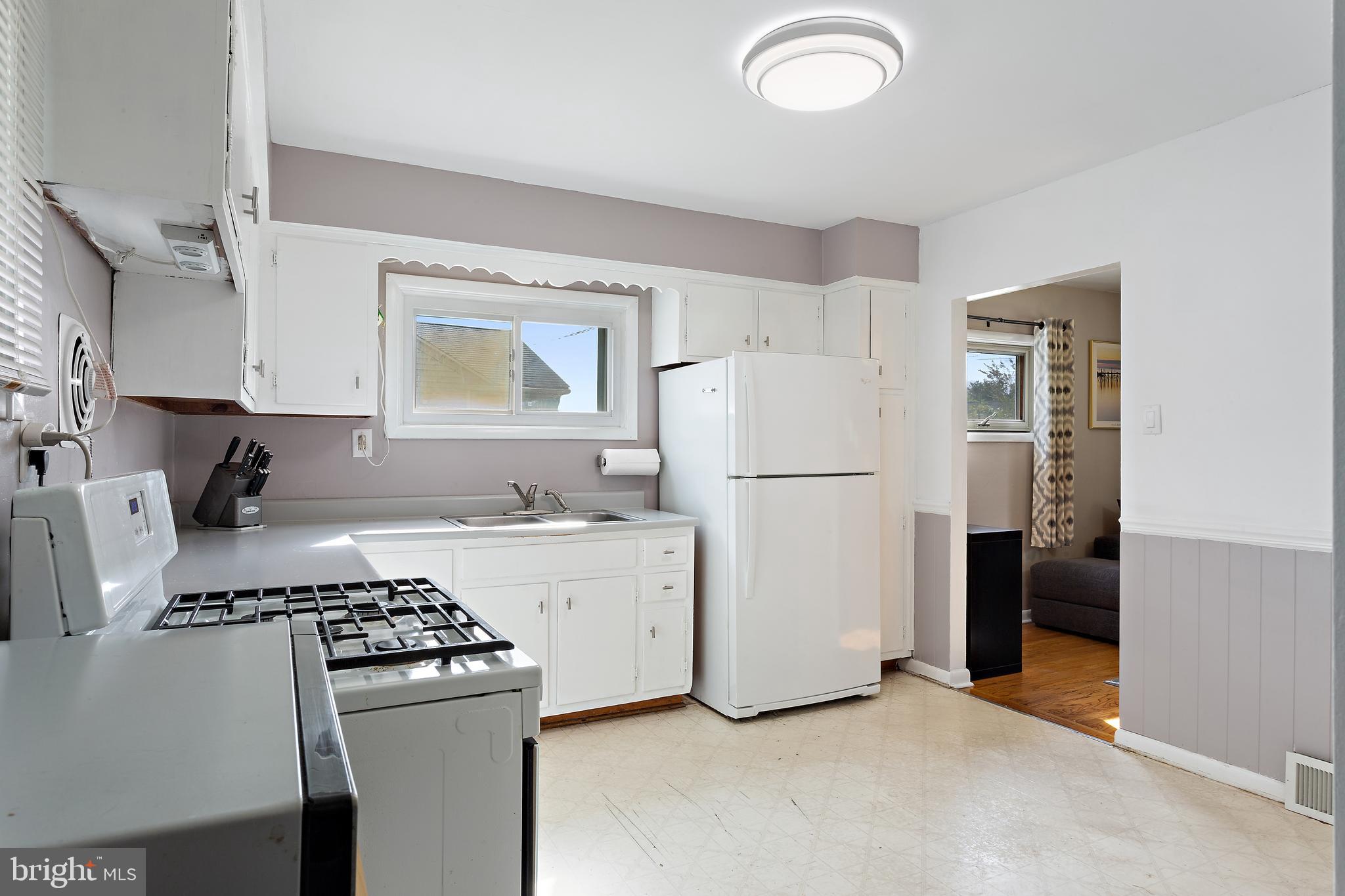 332 Baldwin Road Glassboro, NJ 08028 - Photo 9 of 24 a kitchen with a refrigerator a stove top oven a sink and cabinets