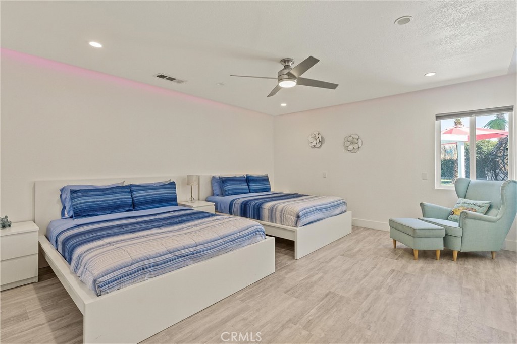 68190 Galardo Road Cathedral City, CA 92234 - Photo 12 of 24 a spacious bedroom with two beds and a chandelier