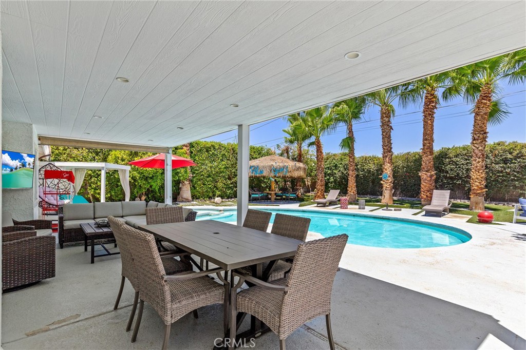 68190 Galardo Road Cathedral City, CA 92234 - Photo 18 of 24 a view of a patio with a dining table and chairs with plants and wooden fence