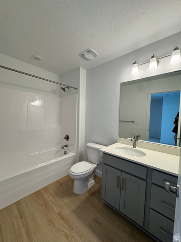1472 North 1875 West, Unit 151 Layton, UT 84041 - Photo 12 of 20 Bathroom featuring a tub/shower combination with a shower rod, a toilet, a single vanity with a solid surface countertop, a rectangular mirror, and wood-finish flooring