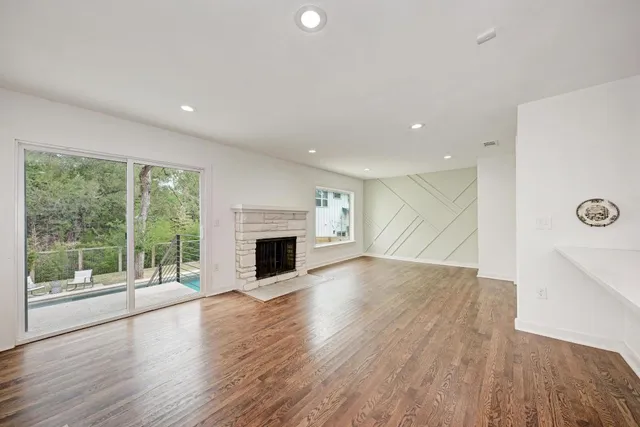 a view of empty room with wooden floor and fireplace