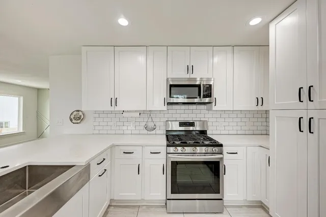 a kitchen with cabinets stainless steel appliances a sink and a counter space