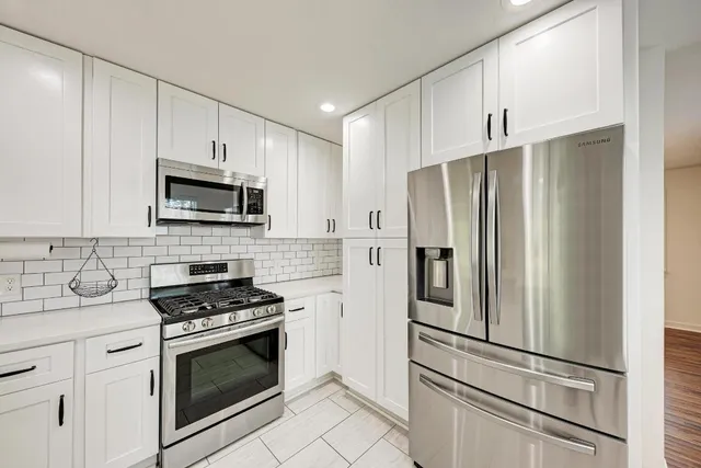 a kitchen with stainless steel appliances a refrigerator stove and microwave
