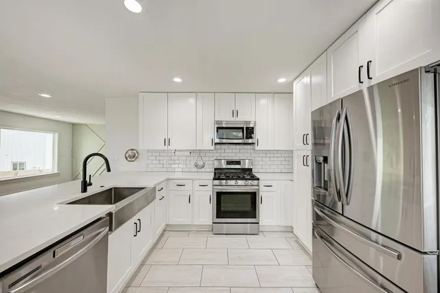 a kitchen with stainless steel appliances granite countertop a refrigerator sink and stove