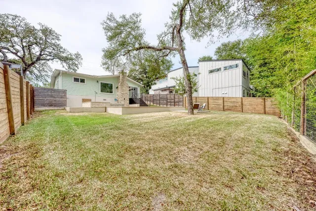 a backyard of a house with table and chairs