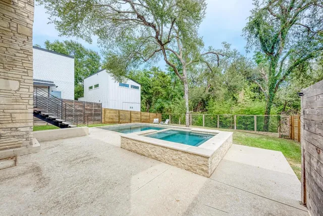 a view of backyard with swimming pool and seating space