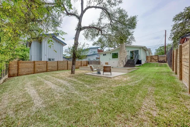 a backyard of a house with table and chairs