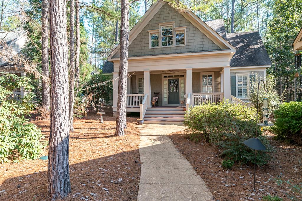 a view of a white house with a large windows and large tree